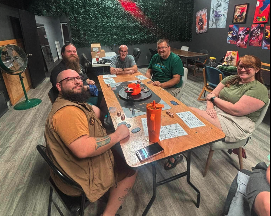 A group of players gathered around a table for game night at Dragon Door Collectibles
